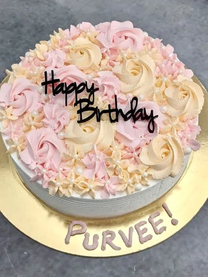 A top-down view of the floral cream cake, showing the lovely blend of pink and yellow rosettes.