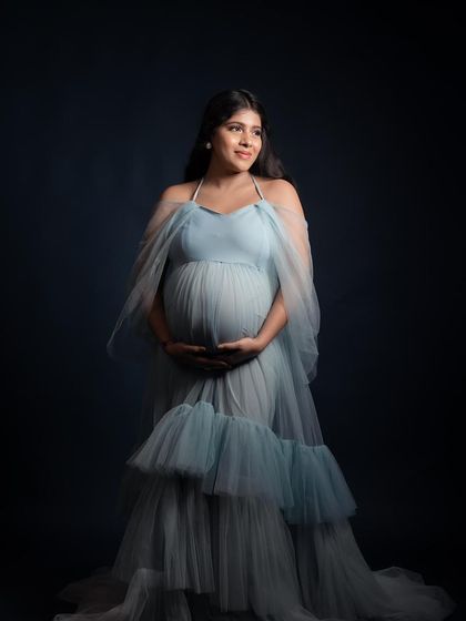 A studio portrait in our Winter gown against a dark backdrop. The contrast makes the light blue tulle pop, creating a dramatic and artistic look.