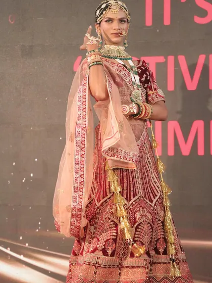 The model strikes a classic pose, fully embodying the bridal character.