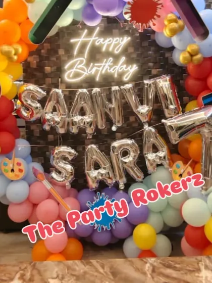 A full view of the Art Party setup, with the birthday girls' names in large silver foil balloons.