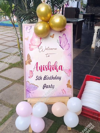 A welcome sign for a 5th birthday party with a pink butterfly theme.