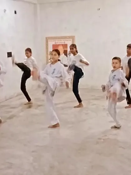 I am demonstrating the correct way to execute a kick, and the students are following my lead.