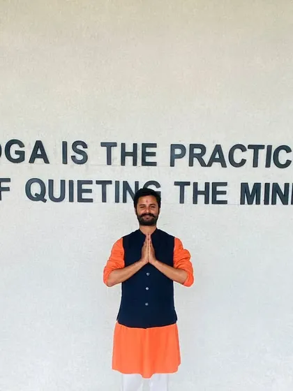 Standing before the words that define our mission: "Yoga is the practice of quieting the mind." This is the ultimate goal of all our efforts and the central teaching I impart to my students.