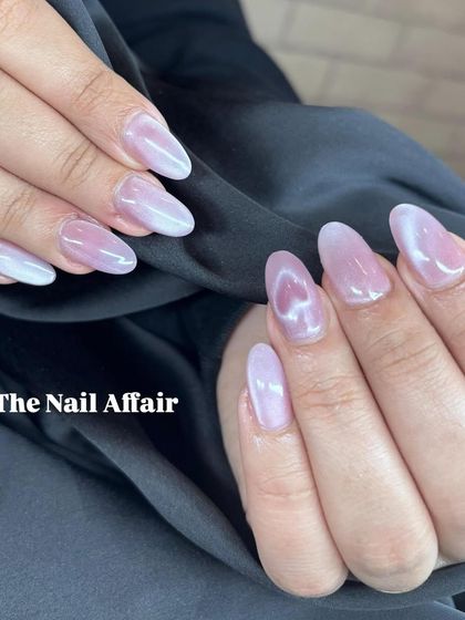 A soft and ethereal cat eye effect in a light pink, pearly shade on almond-shaped nails.