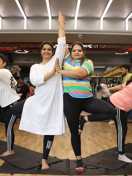 Members practicing the Tree Pose (Vrikshasana), a fundamental posture for improving balance and focus.