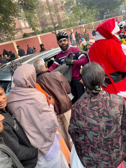 A member helping distribute blankets to the needy from a car during our Christmas charity event.