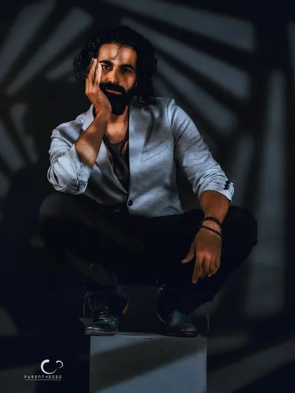 A portrait is a conversation between light and shadow. Here, I used gobo lighting to create a spiral pattern, framing the subject's intense and quiet presence. It’s a study in masculine portraiture, focusing on introspection over overt expression.