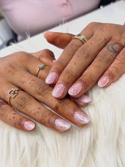 A sweet and simple way to use a chrome effect. These nails have a subtle pearlescent finish that gives them a healthy glow, which I decorated with delicate white polka dots for a fun, classic design.
