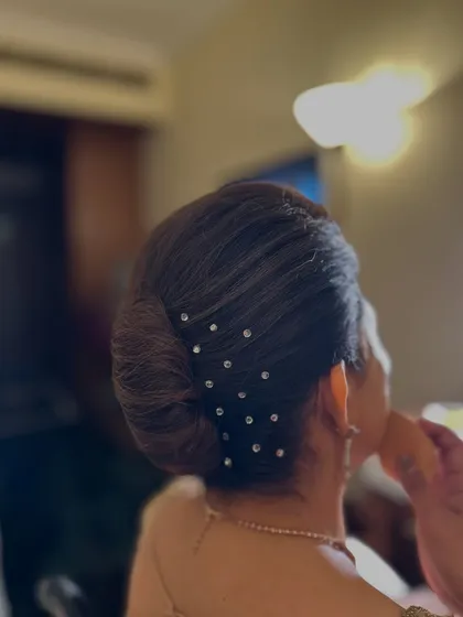 Another angle of the crystal-studded French knot. This view shows how the placement of the pins enhances the shape of the elegant, classic hairstyle.