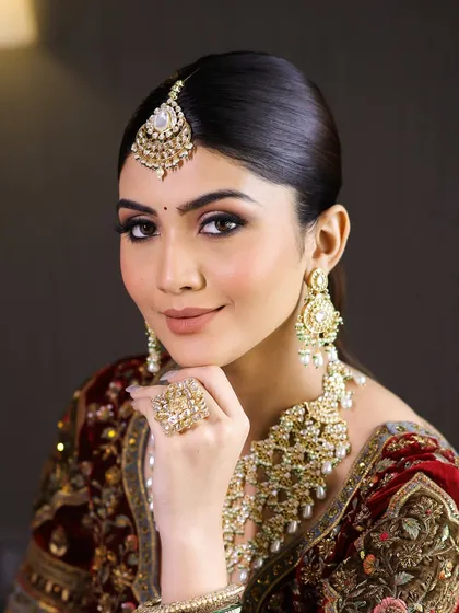 A confident and beautiful bridal portrait. The makeup is glamorous yet timeless, with a focus on enhancing the bride's natural features.