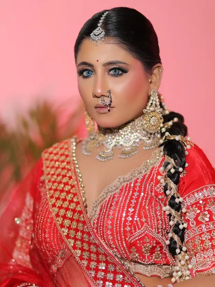 A powerful bridal portrait. The combination of a classic red lehenga, diamond jewelry, and striking blue eyes creates a truly unforgettable look.