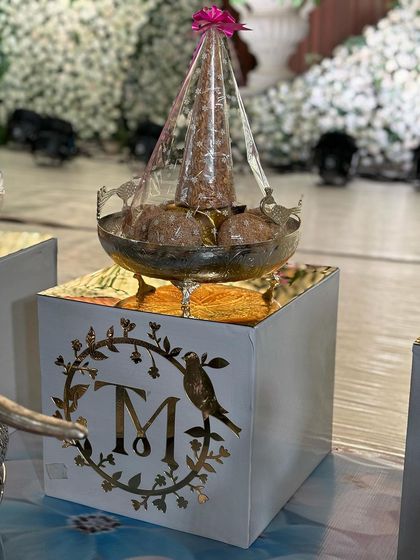 A personalized offering box with a custom monogram, adding a modern touch to the traditional setup.