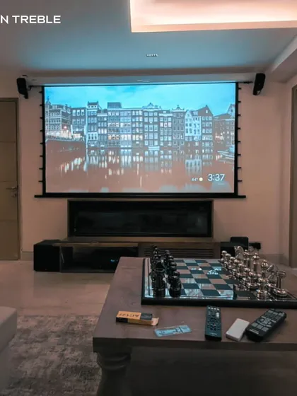 This living room setup features a large roll-down screen and a complete surround sound system, ready for an epic movie marathon. We design systems that are both powerful and practical for everyday living.