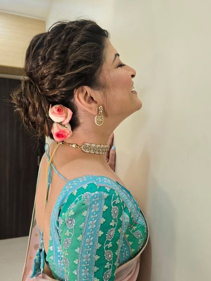 A close-up of the romantic floral updo. The fresh roses add a beautiful, fragrant touch to the hairstyle.
