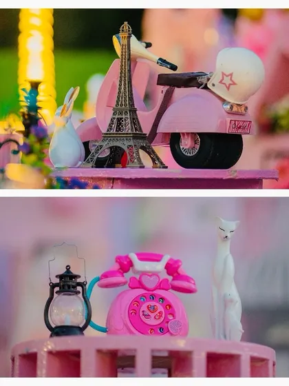 A collage of miniature props, including a pink scooter with an Eiffel Tower and a vintage pink telephone.
