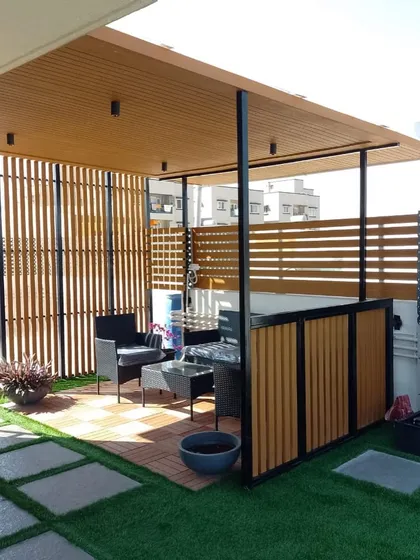 Here we built a complete outdoor room under a pergola, with slatted wood screens for privacy and a checkerboard deck for the seating area. It’s a perfect example of creating a defined, functional zone on a large terrace.