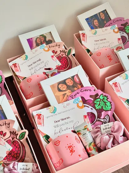 Inside these bridesmaid boxes, I've included a custom-printed mug, a personalized photo frame, hand cream, a face mask, and a scrunchie.