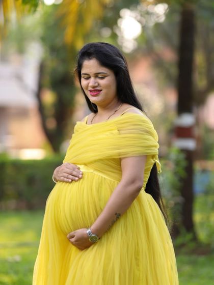 A close-up of our yellow off-shoulder maternity gown. The delicate tulle and bright, sunny color are perfect for capturing the radiant glow of a mother-to-be.