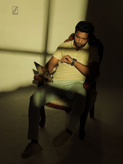 A pose that interacts with the light and shadow, as if the subject is checking the time in a sliver of sunlight.