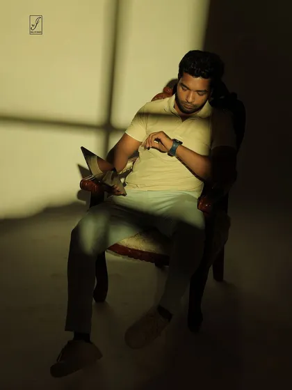 A pose that interacts with the light and shadow, as if the subject is checking the time in a sliver of sunlight.