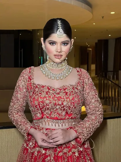 A front-facing portrait of the bride. The styling focuses on the clean lines of the square neckline and the intricate embroidery of the blouse.
