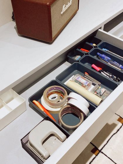 An organized office supply drawer. Using modular trays, we created compartments for tape, pens, staplers, and other stationery items.