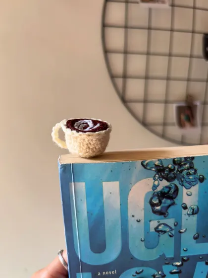 Another look at the coffee cup bookmark, peeking out from the top of a book.