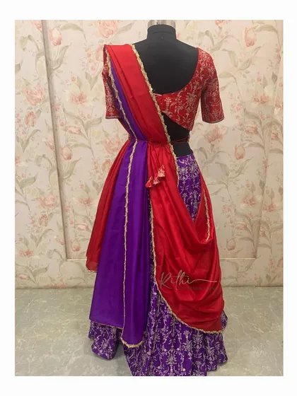 The back view of the red and purple half-saree, showing how the dupatta is elegantly draped and attached to the skirt for a seamless look.