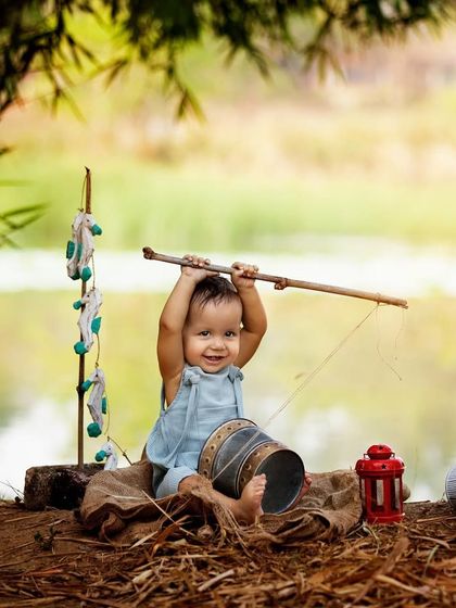 Look at that big, happy smile! He's so proud of his 'catch'. Themed outdoor shoots like this fishing adventure are a great way to get playful and memorable photos of your little one.
