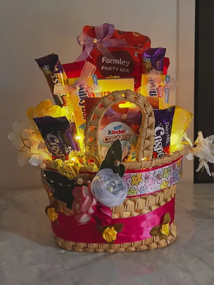 A beautifully lit shot of the yellow chocolate basket at night. The fairy lights make the chocolates and snacks look even more tempting.