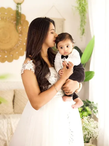 A mother's gentle kiss for her little gentleman. This shot captures the sweet bond in our lush, green-themed boho studio setup.