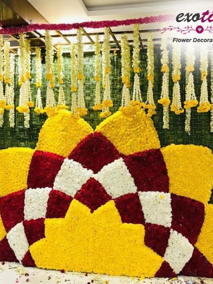 A geometric floral backdrop made from yellow, red, and white flowers. This design combines traditional colors with a modern pattern for a unique festival decoration.