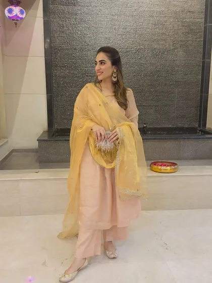 Another shot of the peach suit with the golden dupatta, showing how it looks in a different light. It's a versatile outfit for day or evening events.