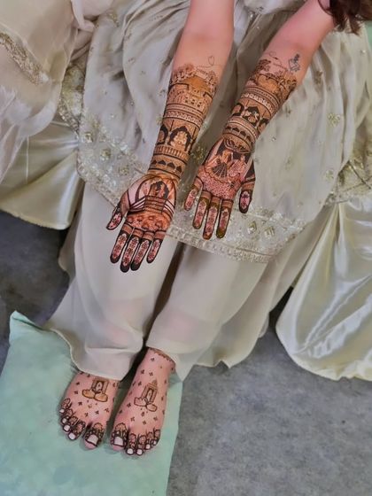 A full-length shot showing the client's coordinated hand and foot mehandi.