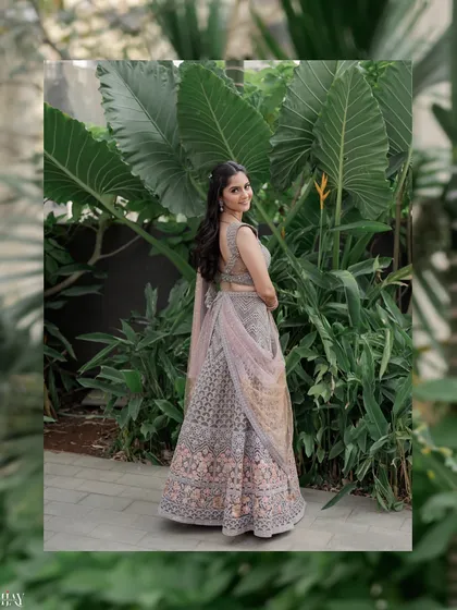 A graceful portrait of the bride looking over her shoulder. The large green leaves in the background create a natural frame, adding a touch of tropical beauty to the image.