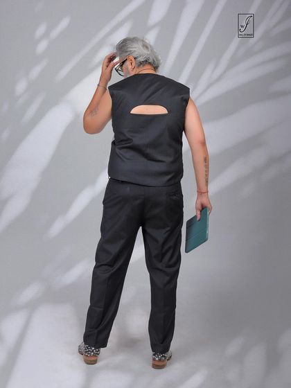 A rear view of the outfit, highlighting the unique cutout detail on the back of the vest.