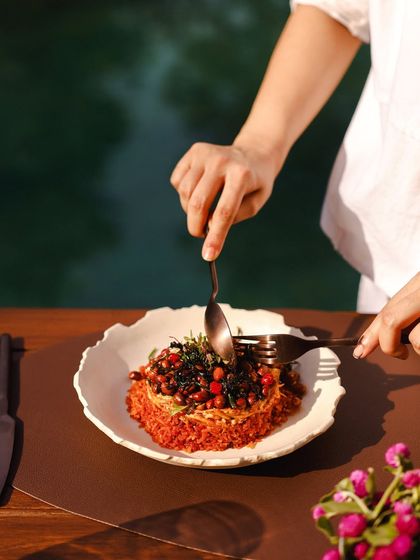 A guest enjoys a colorful rice dish by the pool, a perfect example of our gourmet poolside dining.
