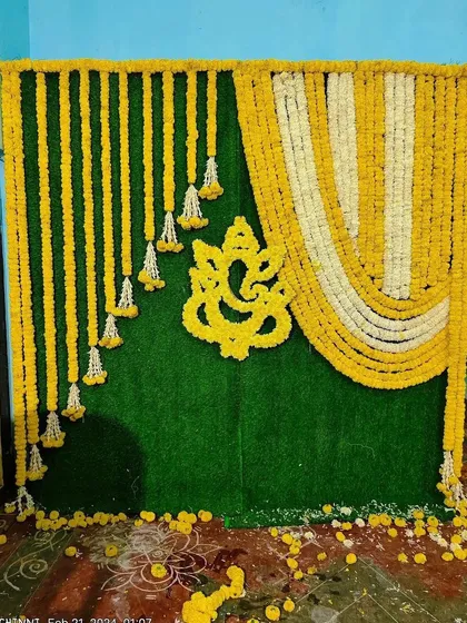 We honor tradition with classic floral backdrops perfect for pujas, housewarmings, or pre-wedding functions. This design features a Ganesha motif made entirely of marigolds against a lush green panel, bringing blessings and beauty to your event.