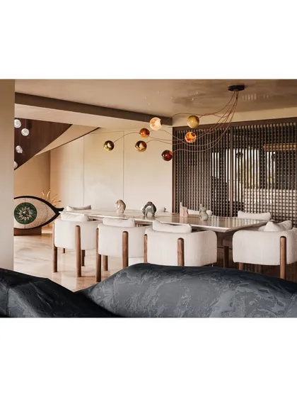 The dining room, featuring a long marble table, contemporary chairs, and a striking, multi-pendant light fixture. The large wooden screen provides a sense of intimacy while maintaining an open feel.