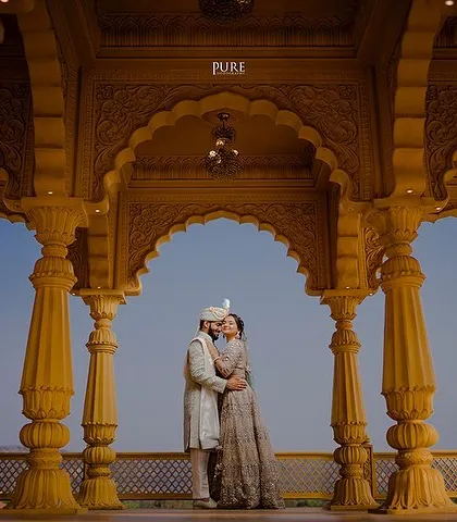 We bring royal dreams to life with shoots set against majestic architecture. This portrait, framed by grand Rajasthani-style arches, captures the elegance and grandeur of a timeless love story.