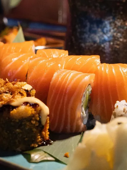 A close-up of a Philadelphia maki roll, showing the layers of fresh salmon, cream cheese, and avocado.