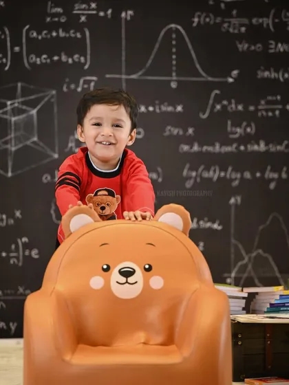 A joyful, candid moment from the 'little genius' shoot, capturing a huge, happy smile.