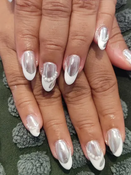 This is a high-impact look combining a reflective silver chrome finish with a white French tip style. To add more dimension, I placed a few small pearls along the cuticle line, creating a design that's both futuristic and elegant.