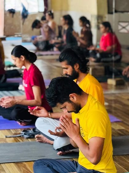 A group of students in my class, sitting in prayer or meditation. This practice of devotion and discipline is a key part of our advanced yoga sessions.