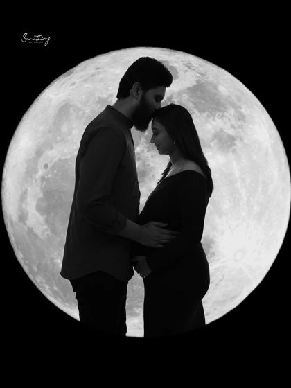 A classic and tender silhouette of a couple against the moon. The husband's gentle forehead kiss and their close embrace make this a deeply romantic and timeless shot.