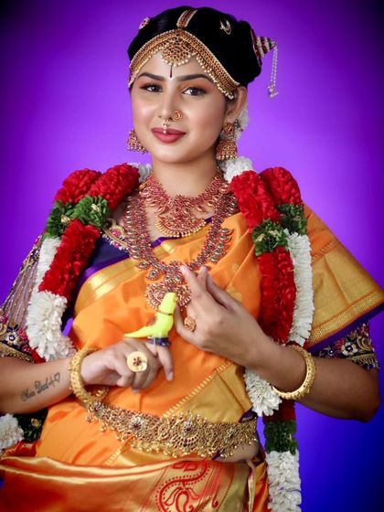 A model in a traditional Andal bridal look, wearing a full set of our temple jewellery. The vibrant yellow saree makes the jewellery stand out.