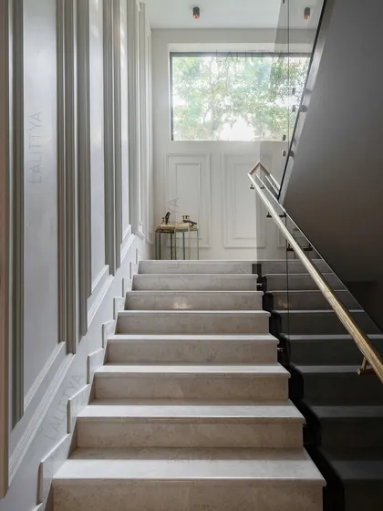 We designed this stairwell to feel like a silent sculpture. The clean marble treads, detailed wall paneling, and soft light from the high window create a serene and structured ascent. The landing is intentionally minimal, offering a moment of pause.
