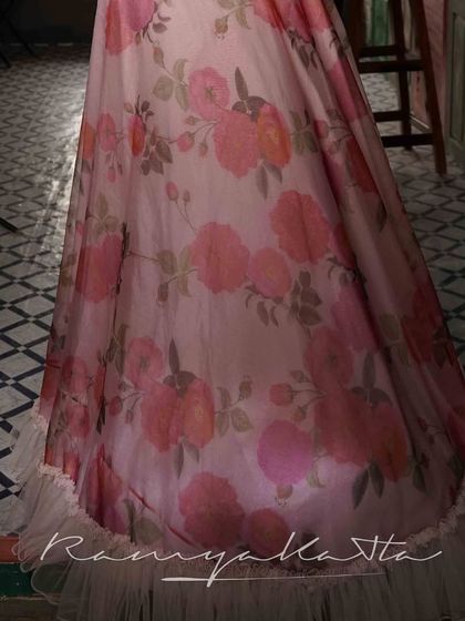 The hem of the organza skirt is finished with a delicate tulle frill, adding to its dreamy and ethereal quality.