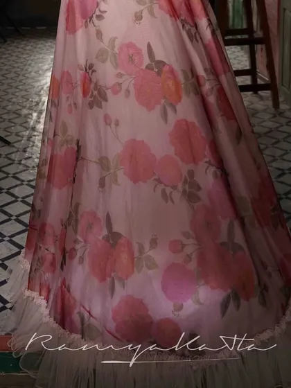 A detail of the printed organza skirt, showing the beautiful floral pattern and the delicate tulle frill at the hem. A design that is both romantic and modern.