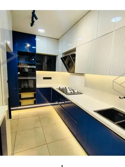 This is a great example of a modern modular kitchen I designed. The combination of high-gloss blue and white handle-less cabinets creates a clean, contemporary look, while the under-cabinet lighting adds warmth and improves visibility. Every element, from the built-in appliance unit to the smart storage, is planned for maximum efficiency.